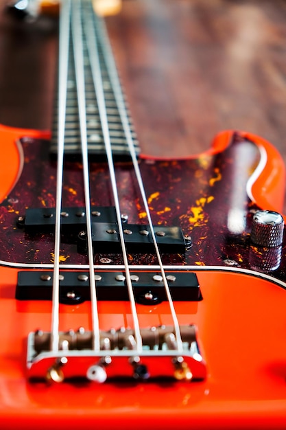 Photo guitare basse électrique orange sur fond de bois avec espace de copie