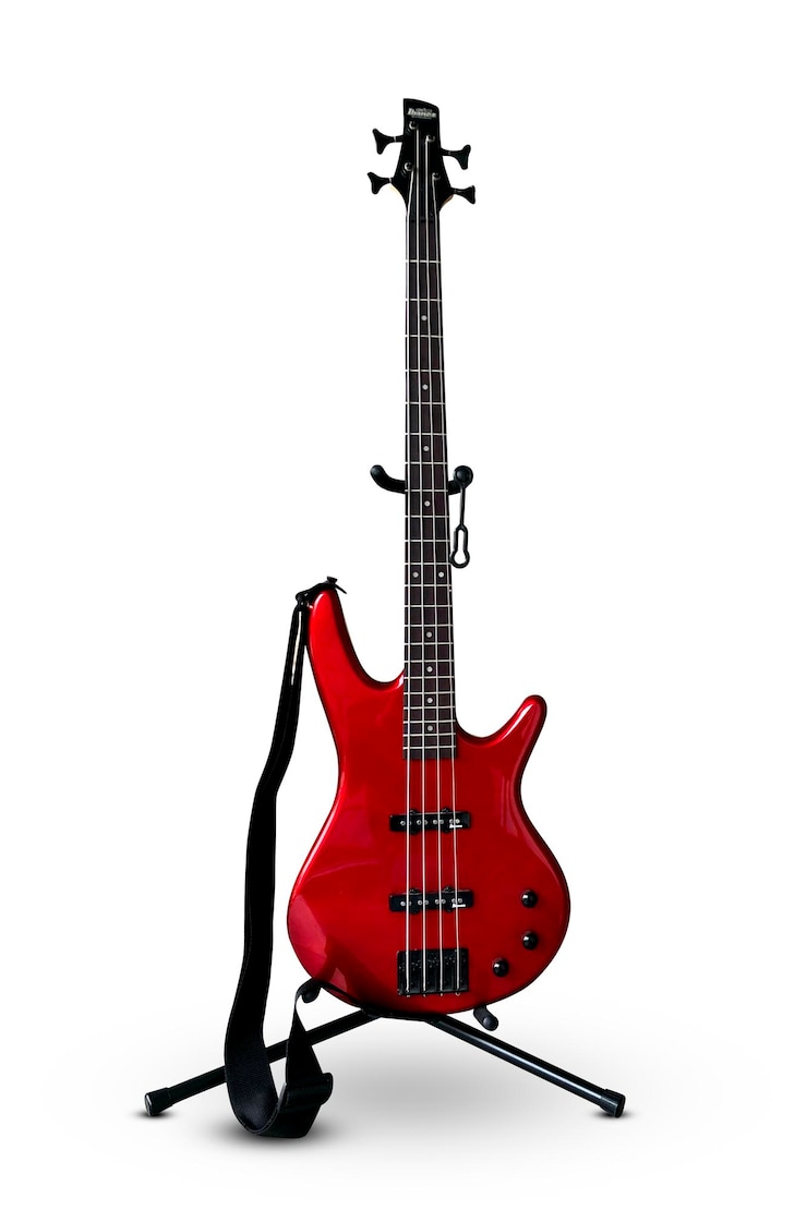 Photo guitare basse rouge avec une sangle isolé sur fond blanc