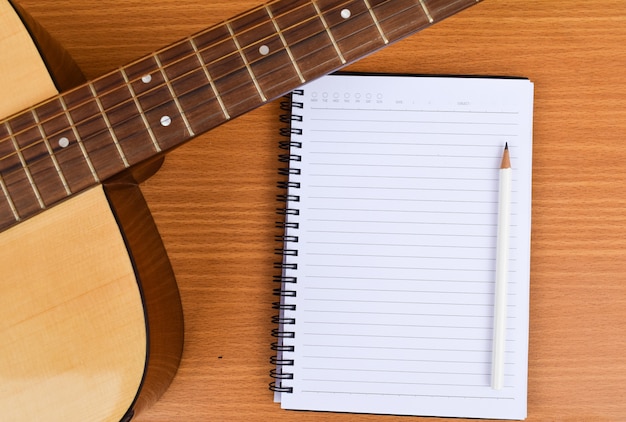 guitare classique avec bloc-notes et crayon blanc