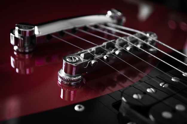 Guitare électrique rouge avec cordes cou gros plan isolé sur fond noir