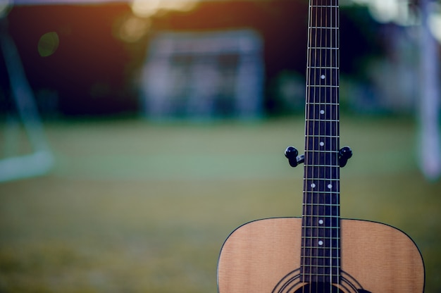 La guitare est placée dans une pelouse verte. Concept musical Et il y a un espace de copie.