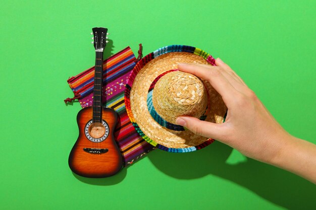 Photo guitare de tapis mexicaine et sombrero sur fond vert