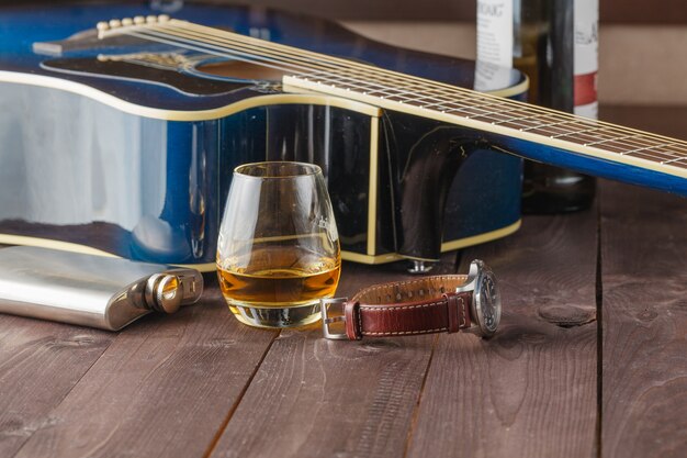 Guitare et verre d'alcool sur table