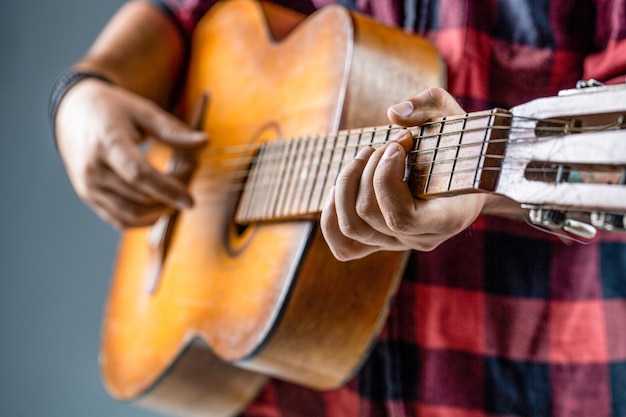 Guitares acoustiques jouant du guitariste sur scène Gros plan main jouant de la guitare Guitares acoustiques Musicien masculin jouant de la guitare instrument de musique Mains de l'homme jouant de la guitare acoustique gros plan