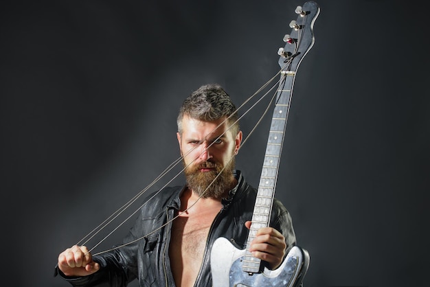 Guitariste amateur de musique en veste avec guitare électrique rock ou concert de musique punk homme barbu avec