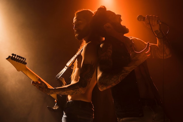 Photo guitariste et chanteur dos à dos sur scène