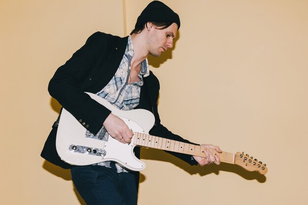 Guitariste jouant pensivement la guitare en gros plan