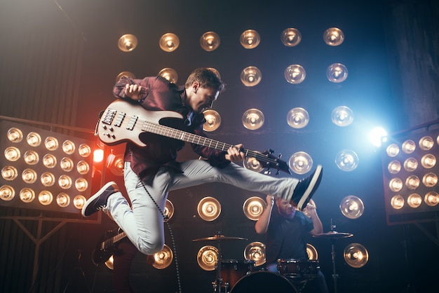 Le guitariste joue à la basse-guitare, instantané dans un saut