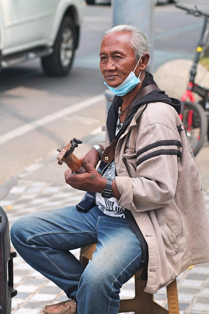 Photo un guitariste joue sur le trottoir.