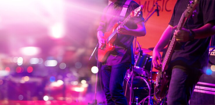 Photo guitaristes avec un éclairage coloré sur une scène
