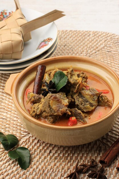 Le Gulai Sapi est un plat traditionnel au curry de bœuf de Padang, dans l'ouest de Sumatera, en Indonésie. Servi à Table avec Bol et Ketupat Lebaran. Menu pour l'Aïd al Adha (Idul Adha)
