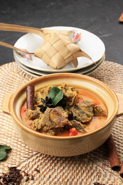 Le Gulai Sapi est un plat traditionnel au curry de bœuf de Padang, dans l'ouest de Sumatera, en Indonésie. Servi à Table avec Bol et Ketupat Lebaran. Menu pour l'Aïd al Adha (Idul Adha)