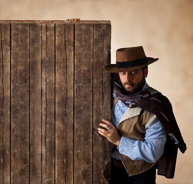 Gunfighter près de table vierge en bois.