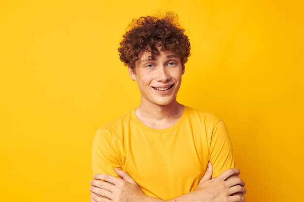 Guy aux cheveux bouclés rouges portant des lunettes élégantes t-shirt jaune posant Lifestyle inchangé