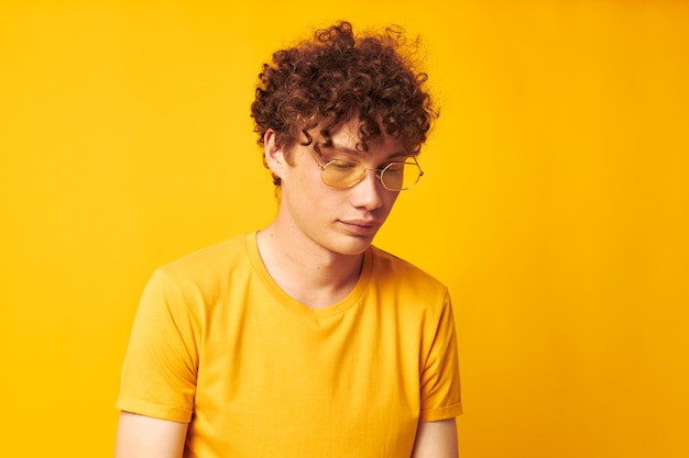 Guy aux cheveux bouclés rouges tshirt jaune lunettes mode gestes de la main style de vie inchangé