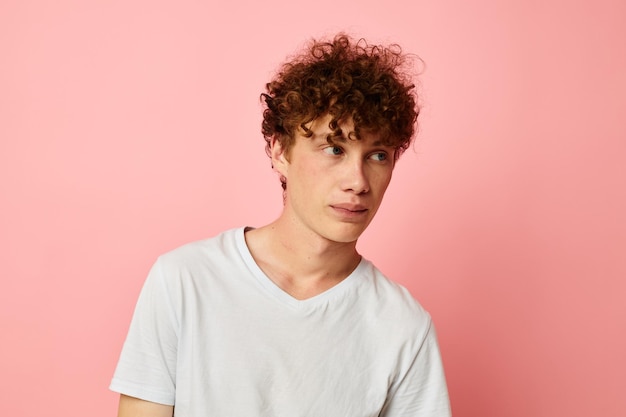 Guy aux cheveux bouclés rouges vêtements d'été tshirt blanc posant fond isolé inchangé