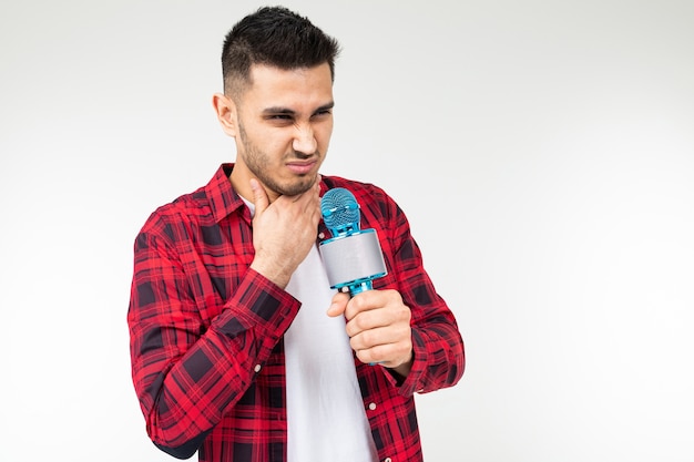 Guy chante au karaoké tenant un microphone à la main sur un fond blanc.