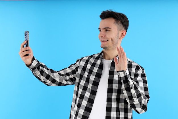 Guy en chemise avec téléphone sur fond bleu