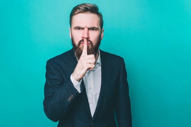 Guy en colère debout et montrant un signe de silence