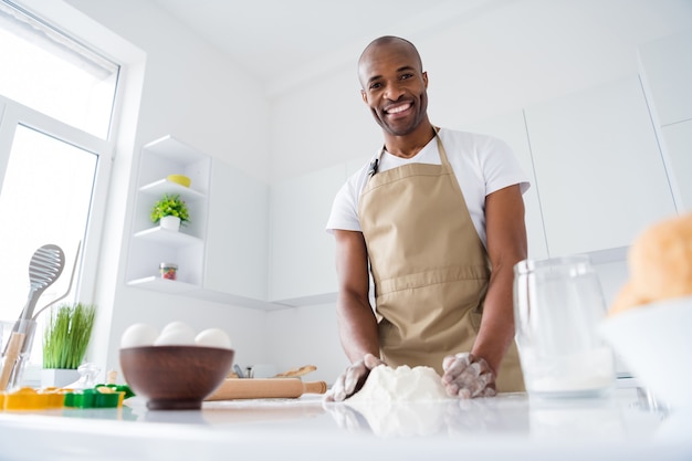 Guy confiseur faisant du pain frais pâte à pain oeufs de farine culinaires dans une cuisine intérieure moderne