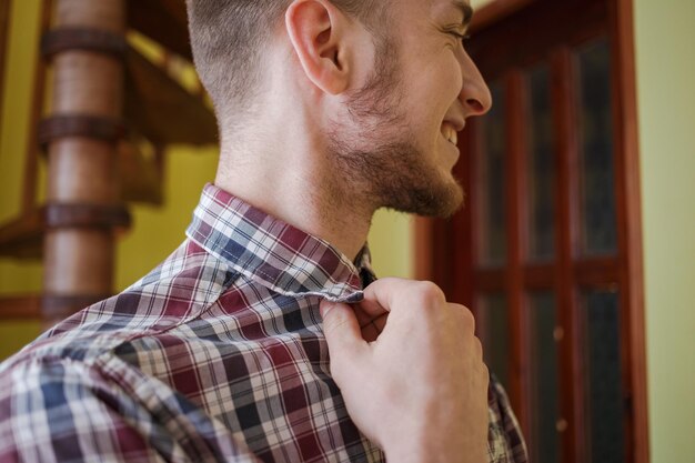 Guy dans une chemise à carreaux redresse les vêtements