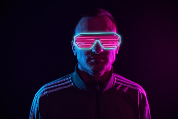 Guy dans des cyber lunettes néon sur un concept de cyber espace de fond sombre