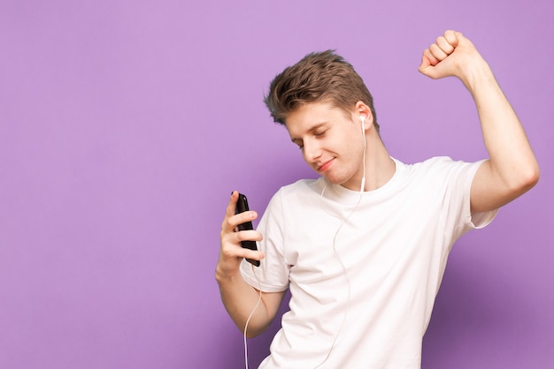 Guy dans un T-shirt blanc dansant avec un casque isolé