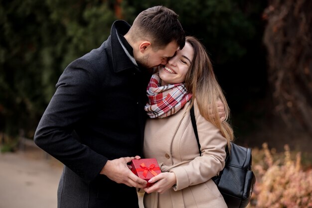 Guy donne une boîte de fille avec un cadeau