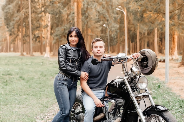 Guy avec une fille dans le parc sur une moto