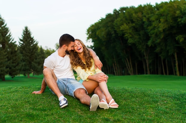 Guy et fille étreignant dans le parc soir date couple heureux amoureux