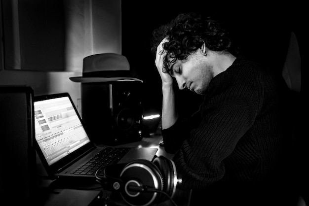 Guy frustré en studio pendant la session de production musicale Image en noir et blanc