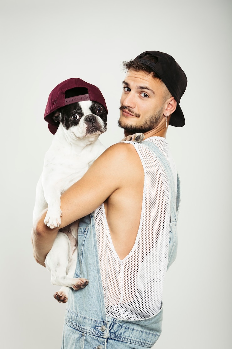 Photo guy hipster serrant son gentil chien bouledogue français sur fond neutre