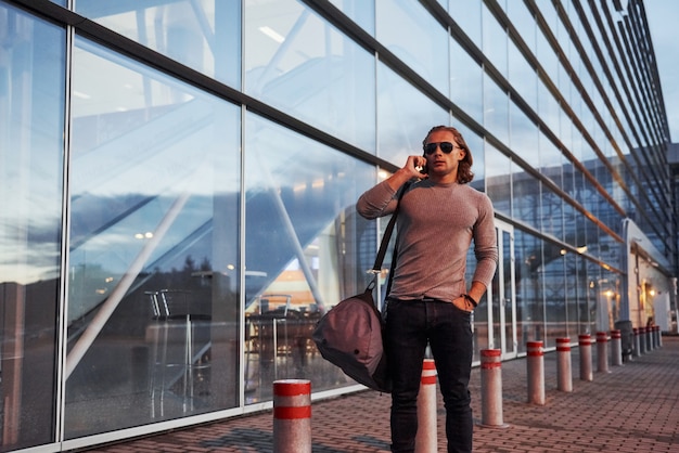 Guy à lunettes de soleil parler au téléphone mobile