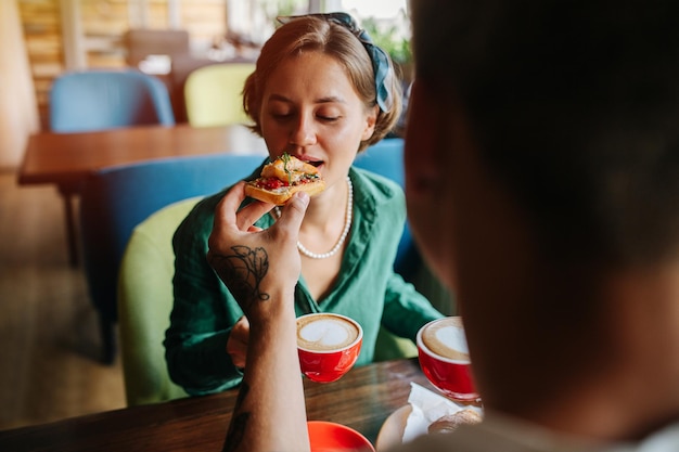 Guy nourrit à la main sa superbe petite amie sensuelle dans un café