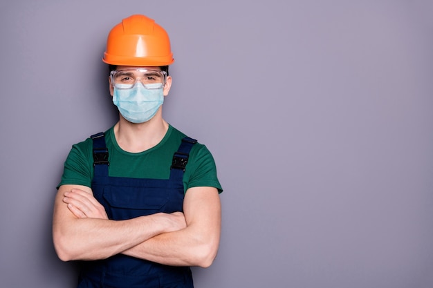 Guy ouvrier porte un masque de protection de sécurité lunettes mers prévention des infections bras croisés