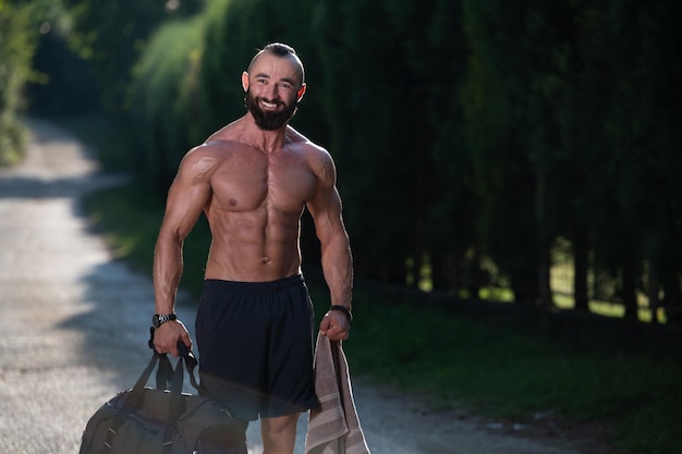 Guy portant un sac de sport à l'extérieur dans le parc