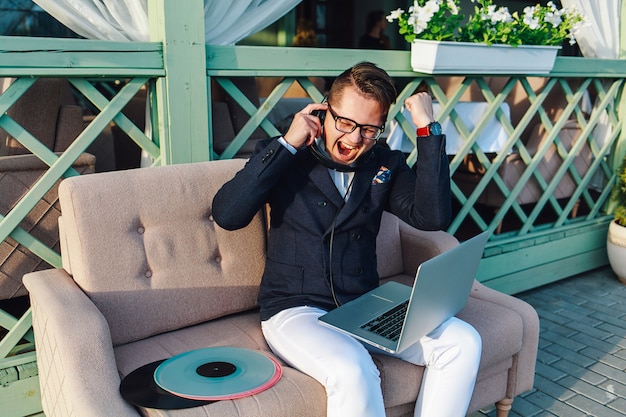 Photo guy positif élégant appréciant la musique à l'extérieur.