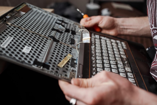 Guy répare un ordinateur portable à la maison