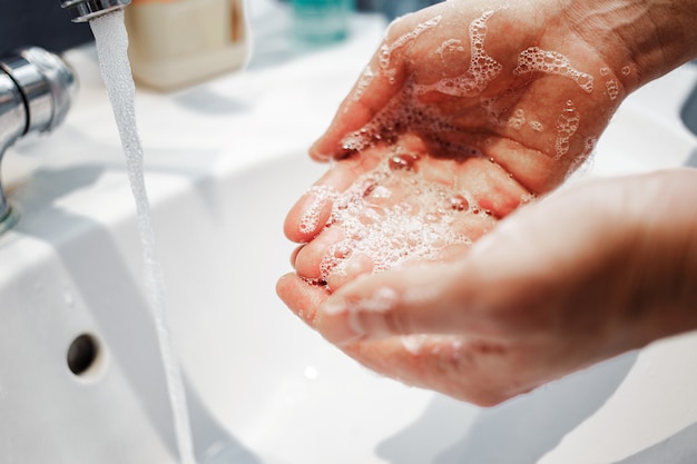 Guy se laver soigneusement les mains avec de l'eau et du savon