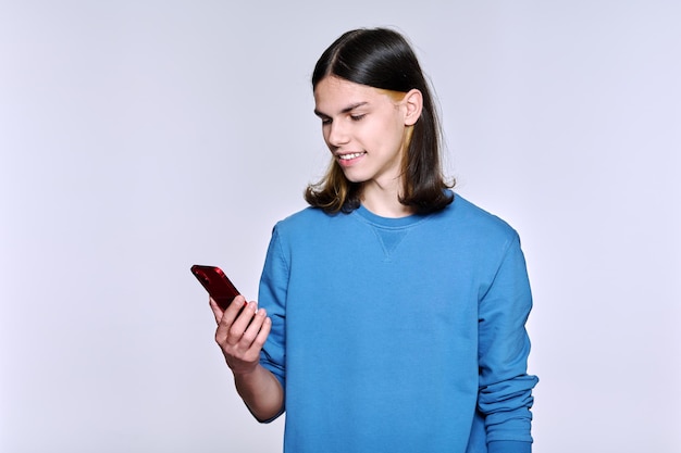 Guy avec smartphone à la main sur fond de studio clair