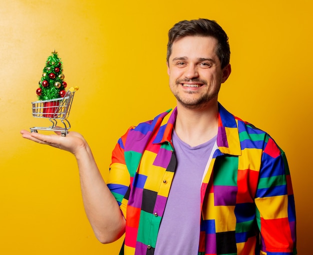 Guy de style en chemise des années 90 avec arbre de Noël dans un panier