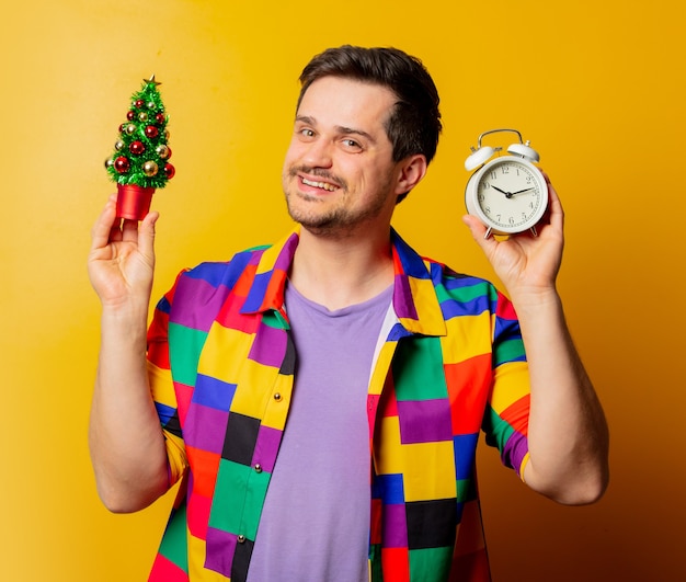 Guy de style en chemise des années 90 avec arbre de Noël et réveil