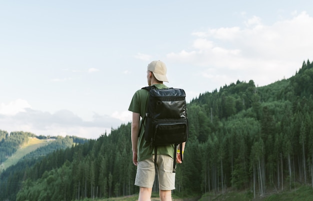 Guy de tourisme appréciant le paysage de la forêt de conifères et le paysage de montagne