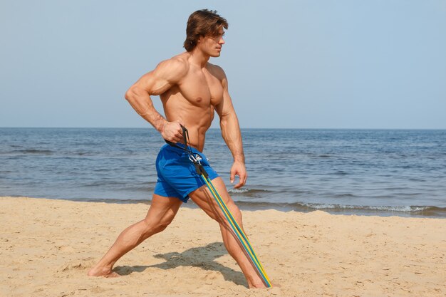 Guy Travaillant Avec élastique Sur La Plage