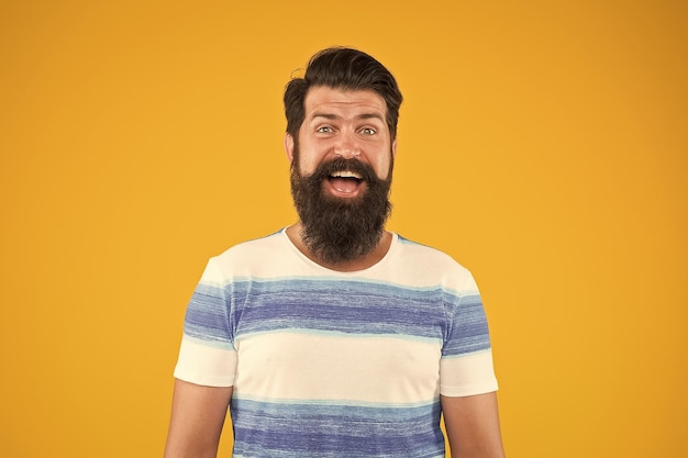 Guy vêtu d'une chemise rayée en vacances d'été Concept de salon de coiffure Homme hipster barbu avec moustache et longue barbe sur fond jaune Vacances d'été Station balnéaire Croisière en mer Style d'été