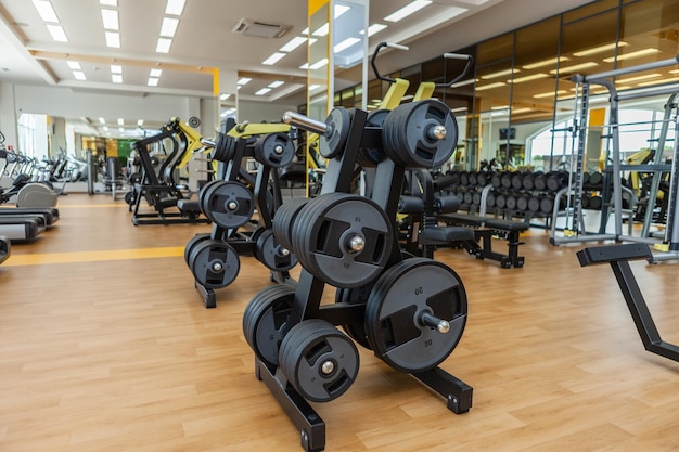 Gymnase moderne et léger. Équipement de sport dans la salle de gym sans personne. Disques haltères sur rack