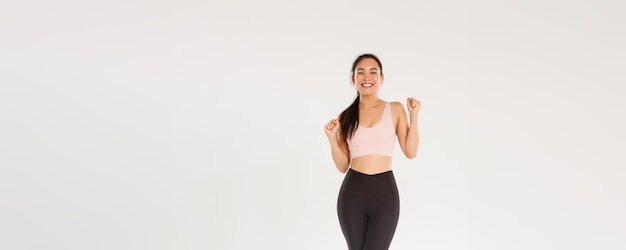 Gymnase sportive et concept de corps sain sur toute la longueur d'une fille brune asiatique encouragée et motivée prête