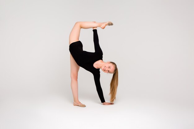 Gymnaste de belle jeune fille, une jeune fille est engagée dans la gymnastique