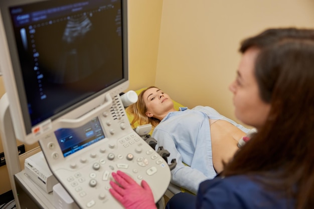 Photo gynécologue effectuant un test de diagnostic par ultrasons pour une patiente