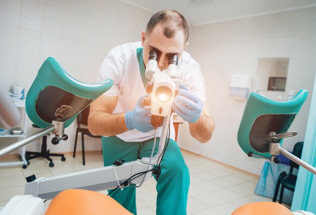 Gynécologue travaillant avec un colposcope en clinique.